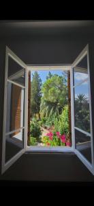 北尼科西亚Sabor Residence的开放式窗户,享有花园的景色