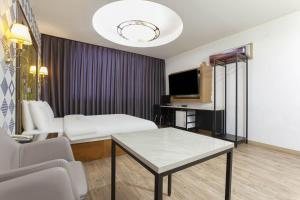 坡州市Carlton Hotel的客厅配有沙发和桌子