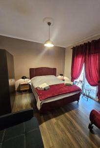 卡瓦拉Majestik Room的一间卧室配有一张带红色窗帘的大床