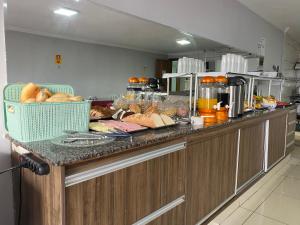纽克莱欧·班代兰蒂Nasser Hotel Aeroporto的厨房配有带面包和美味食品的台面