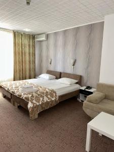 布加勒斯特Darin Hotel的一间卧室配有一张大床和一张沙发
