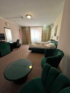 布加勒斯特Darin Hotel的酒店客房带一张床、一张桌子和椅子