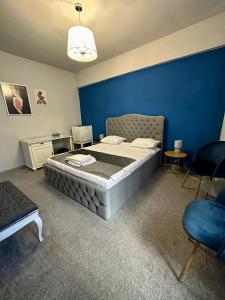 布加勒斯特Darin Hotel的一间卧室设有一张大床和蓝色的墙壁