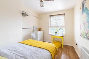 伦敦Stunning 1 bed flat in the heart of Greenwich的一间卧室配有一张床和黄色毯子