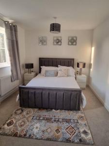 伊普斯威奇Modern 2bedroom House in Ipswich Suffolk的一间卧室配有一张带2个床头柜的大床
