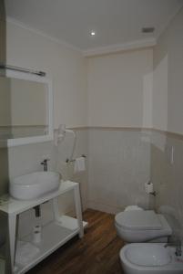 克罗托内太阳神酒店的一间带水槽、卫生间和镜子的浴室