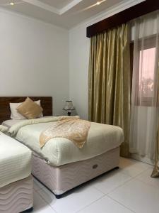 索哈尔SADARA HOTELS APARTMENTS的一间卧室设有一张大床和一个窗户。