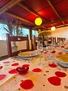 珀蒂蒂勒Domaine de l'Anse的一张桌子,上面放着酒杯和红花