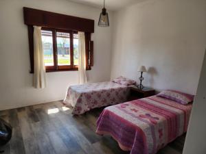 科洛尼亚-德尔萨克拉门托Hermosa vista的一间卧室设有两张床和窗户。