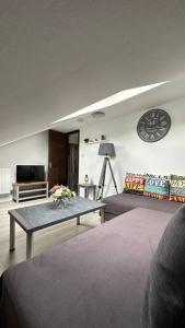 埃德蒙顿Palaz 8 - One Bedroom Flat的客厅配有桌子和墙上的时钟