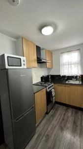 埃德蒙顿Palaz 8 - One Bedroom Flat的厨房配有黑色冰箱和木制橱柜。