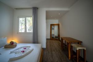 吉汶瓦Ocean View Junior Suite Tatu ZanzibarHouses的一间卧室配有一张床、一张桌子和一个窗户。