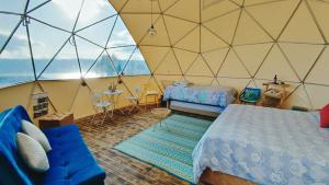 瓜塔维塔Andes Glamping的一间卧室配有一个带一张床和一张沙发的帐篷