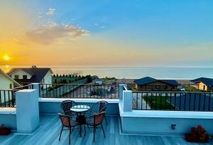 博斯特里Alma Villa Guest House - Bosteri的阳台配有两把椅子和一张桌子,享有海景。