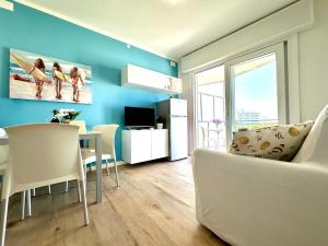 利尼亚诺萨比亚多罗Beach Front Apartment Sabbiadoro的客厅拥有蓝色的墙壁和桌椅