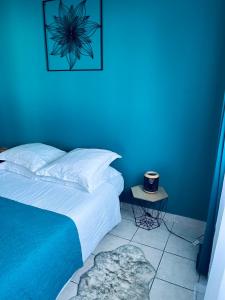 珀蒂蒂勒Villa Longani Passion pour des vacances bucoliques en famille的一间蓝色卧室,配有床和床头柜