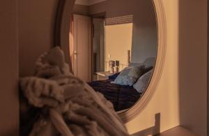 普奇塞达Vistas espectaculares en el centro de Puigcerdà的镜子反射着卧室,卧室里配有一张床