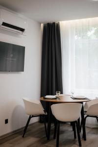 乌日霍罗德Luxury Apartments CITY的一间带桌椅和窗户的用餐室
