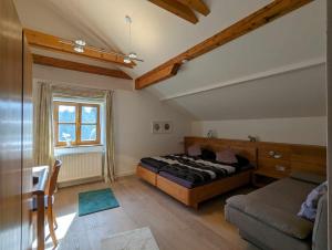 菲利普斯罗伊特Ferienwohnungen Kricklsäge的一间卧室配有一张床、一张沙发和一个窗口