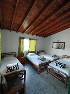 瓜塔佩Hotel Casa Verde Guatapé的带木天花板的三张床