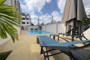 弗利康弗拉克SeaSand-Entire Luxury 3 BD condo - Close to beach的游泳池配有遮阳伞、2把椅子、桌子和遮阳伞