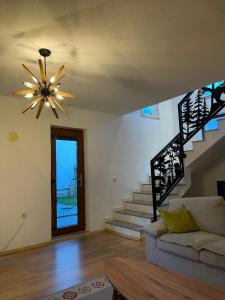 布雷佐维察Villa Alpina Brezovice的一间带吊扇和楼梯的客厅