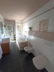 OstopoviceApartmán Rose的浴室配有卫生间、浴缸和水槽。