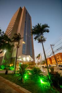贝洛奥里藏特Nobile Inn Pampulha的一座高大的建筑,前面有棕榈树