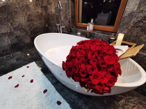 CărpinişAgropensiunea La Bunici的浴缸里一大束红玫瑰
