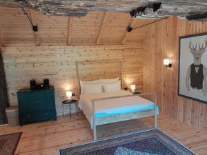 Sremska KamenicaNica Wood的木制客房内的一间卧室,配有一张床