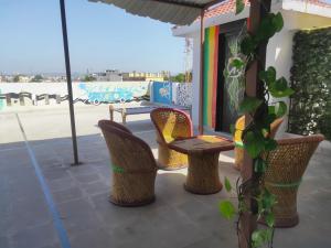 乌代浦Nomadic Hostel的庭院配有桌椅和遮阳伞。