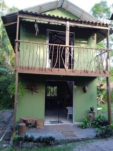 蜜岛Chalé Encantadas Eco Ilha Preserve的一座带木甲板的绿色小房子