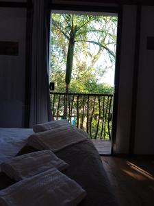蜜岛Chalé Encantadas Eco Ilha Preserve的一间卧室设有一张床和一个大窗户