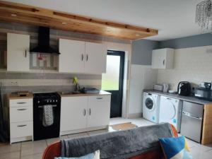 韦斯特波特Self Catering apartment Achill Island Pets Allowed的厨房配有白色橱柜和沙发