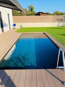 马勒尼科VOO residence的一个带木甲板和蓝色海水的游泳池