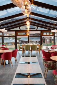 厄尔查尔坦查尔坦套房酒店的餐厅设有桌椅和带窗户的天花板。