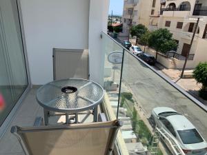 拉纳卡La Veranda Hotel的大楼阳台上的玻璃桌