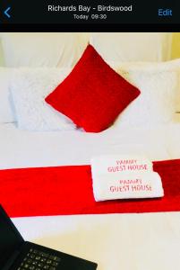 理查兹湾Pammy Guest House的一张红色和白色的床,上面有笔记本电脑