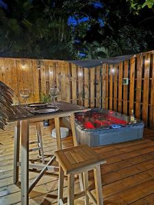 圣罗斯PURA VIDA Lodge Cabane perchée的木甲板配有桌椅和热水浴池。