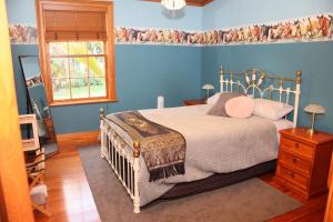 旺格努伊Headlands Estate的蓝色的卧室设有床和窗户