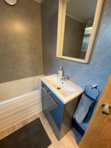 诺丁汉Comfortable 2 bedroom home from home with parking的浴室配有盥洗盆、镜子和浴缸