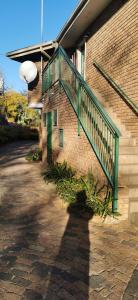 比勒陀利亚Rose Guest House的砖砌建筑一侧的绿色楼梯
