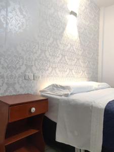 LambayequeLa Posada Norteña的一间卧室配有一张床,墙上配有一盏灯