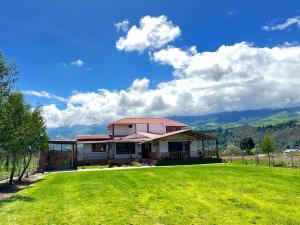 里奥班巴Casa de campo con hermosa vista的前面有绿色草坪的房子