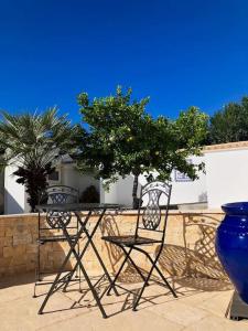 法鲁Villa with pool and sea view with two independent floors的两张椅子和一张桌子以及蓝色花瓶