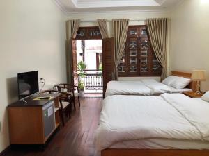 顺化Maya Homestay的酒店客房设有两张床和电视。