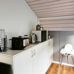 穆奥塔塔尔Muota River & Industry Apartment by Nature Apartments Switzerland的厨房配有带微波炉和电器的白色橱柜。