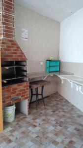 蒙加瓜pousada&Hostel perola mar的厨房配有砖炉和桌子