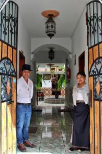 奥塔瓦洛Chaska Hotel的两个人站在房子门口