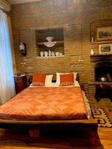 泰拉维Dzveli Galavani -Old Wall的一间卧室设有一张带砖墙的大床